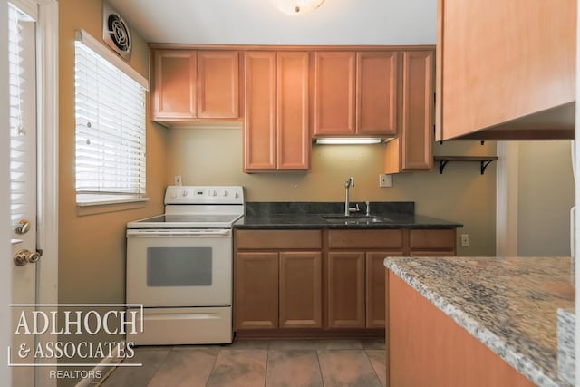 kitchen with light tile patterned floors, white range with electric stovetop, brown cabinets, stone counters, and a sink