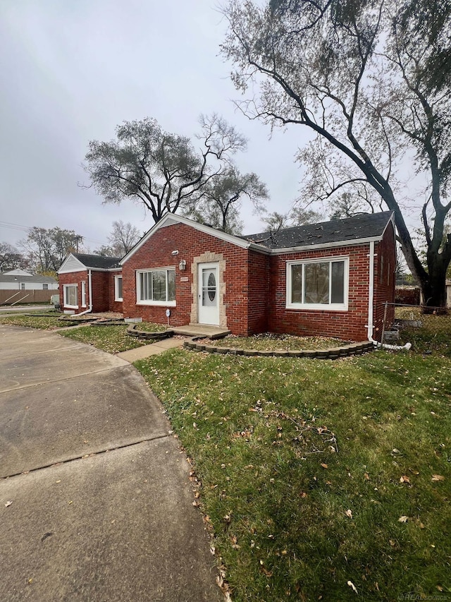 view of front of house featuring brick siding and a front lawn