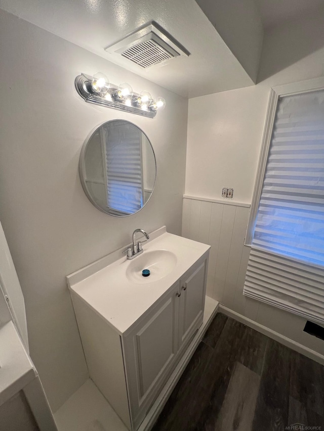 bathroom featuring wood finished floors, wainscoting, vanity, and visible vents