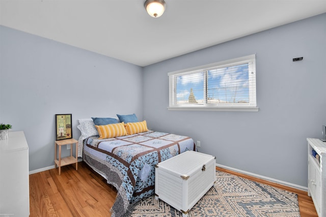 bedroom with baseboards and wood finished floors