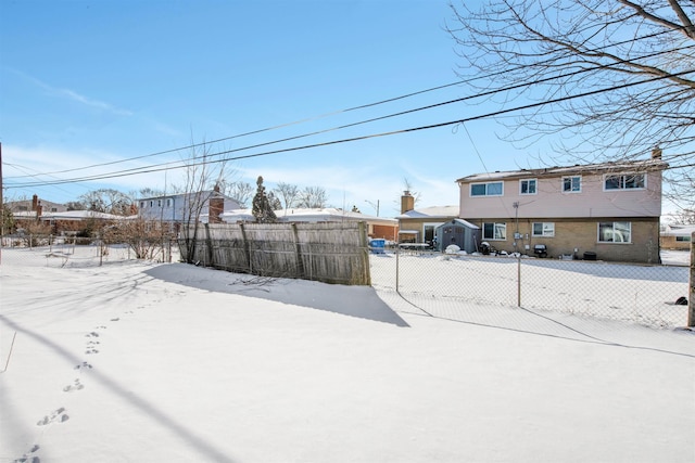 snowy yard featuring a fenced front yard