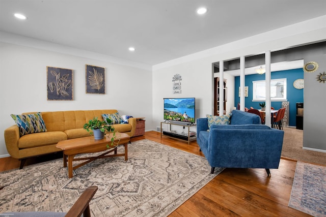 living room with baseboards, wood finished floors, and recessed lighting