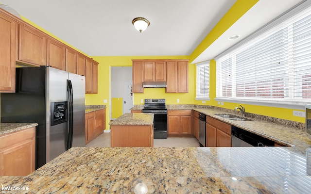 kitchen with light tile patterned floors, under cabinet range hood, stainless steel appliances, a sink, and light stone countertops