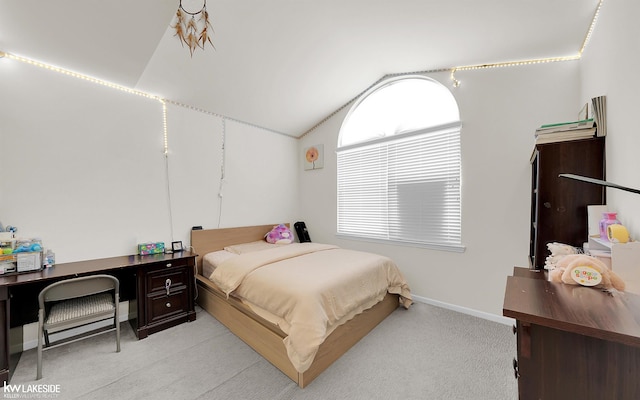 bedroom with vaulted ceiling, light carpet, and baseboards