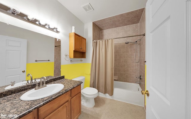 bathroom featuring toilet, vanity, visible vents, tile patterned floors, and shower / tub combo with curtain