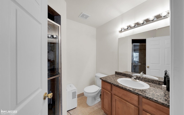 bathroom featuring a shower, visible vents, toilet, vanity, and tile patterned floors