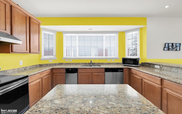 kitchen featuring stainless steel appliances, recessed lighting, a sink, and light stone countertops