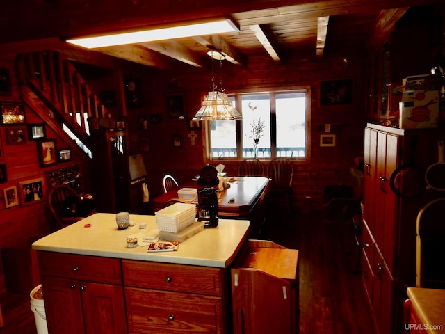 kitchen featuring hanging light fixtures, dark wood-style floors, light countertops, and beam ceiling