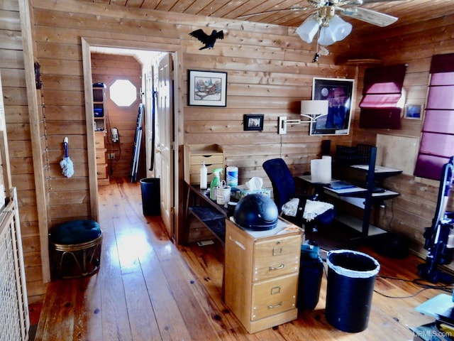 office space with a ceiling fan, wooden ceiling, wood walls, and wood finished floors