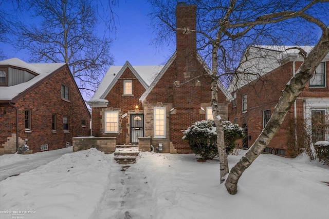 tudor house featuring brick siding