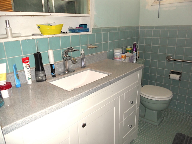 half bathroom featuring toilet, tile walls, and vanity