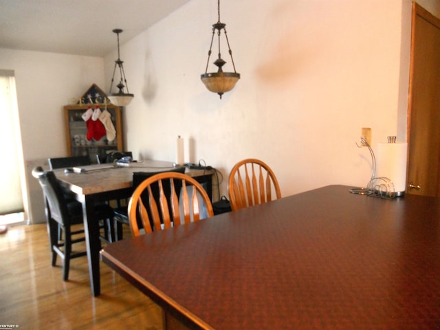 dining room featuring light wood-style floors and vaulted ceiling