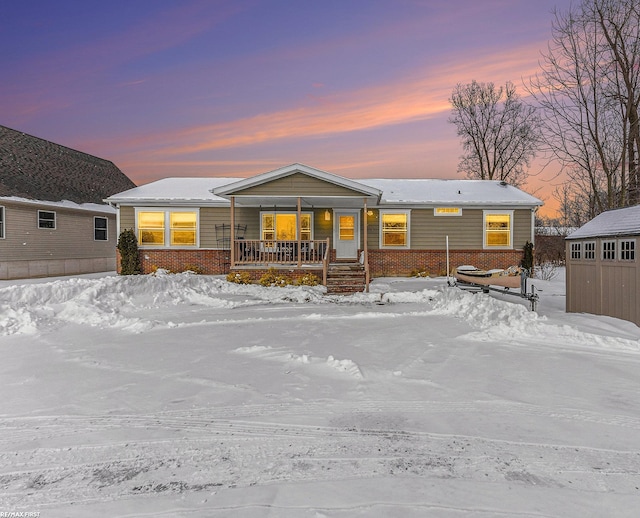 manufactured / mobile home featuring a porch and brick siding