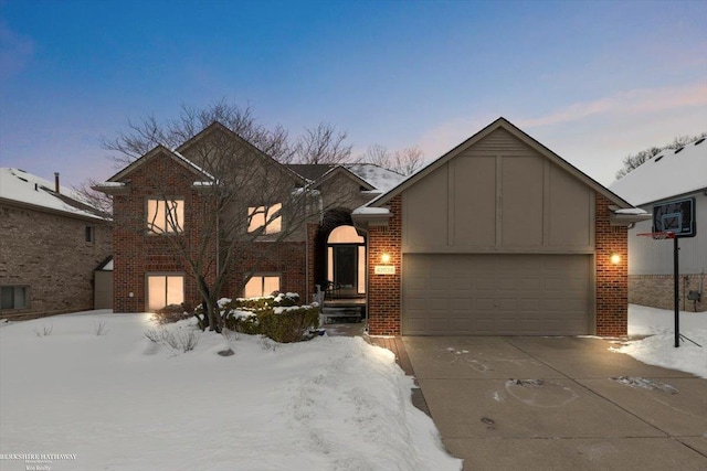 tri-level home with a garage, concrete driveway, and brick siding