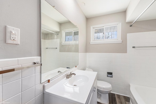 full bath featuring wainscoting, tile walls, vanity, and wood finished floors