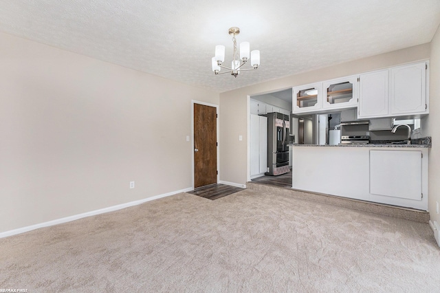 kitchen with dark countertops, light carpet, white cabinetry, and glass insert cabinets