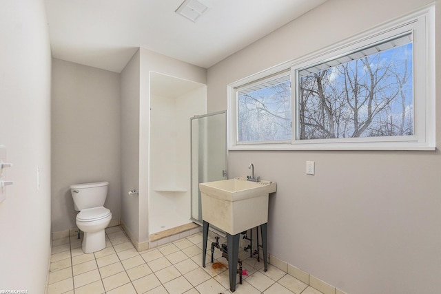 bathroom with baseboards, visible vents, toilet, and tile patterned floors