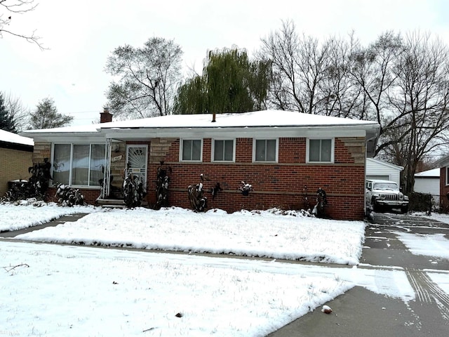 view of front of house with a garage, brick siding, and a chimney