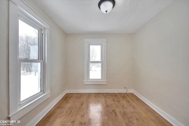 empty room featuring light wood finished floors and baseboards