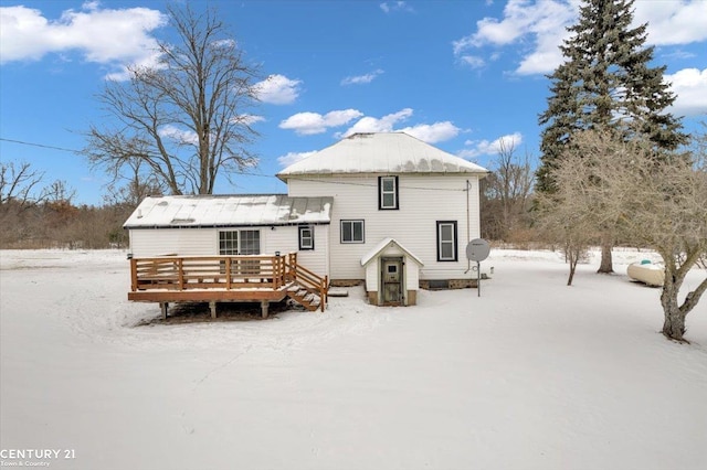 snow covered house with a deck