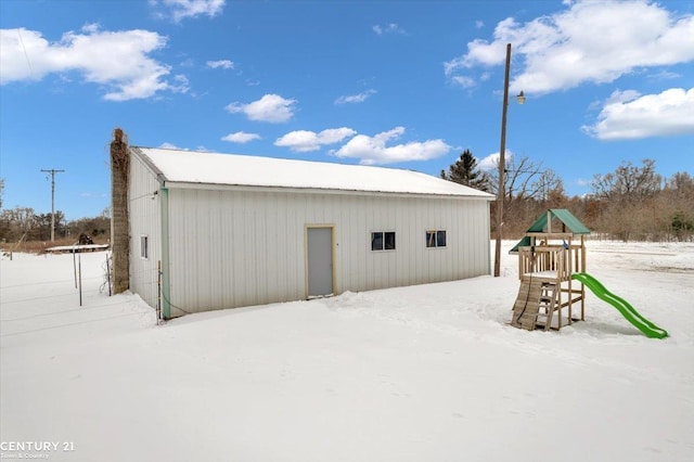 snow covered structure featuring a playground