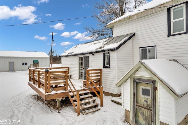 snow covered house featuring a deck