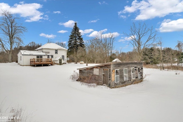 snow covered property with a wooden deck