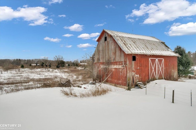 snow covered structure featuring an outdoor structure and a barn