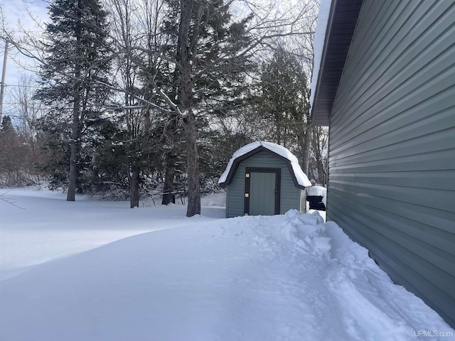 snowy yard featuring an outdoor structure and a shed