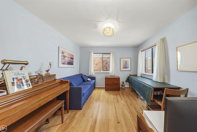 sitting room with a healthy amount of sunlight, light wood finished floors, and baseboards