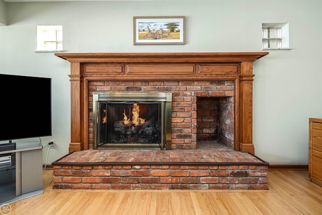 room details with a brick fireplace, wood finished floors, and baseboards