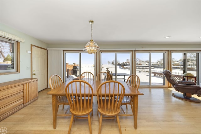 dining room with light wood-style floors and an inviting chandelier