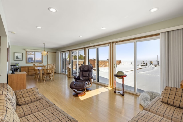 living room featuring light wood-style floors, recessed lighting, and a water view