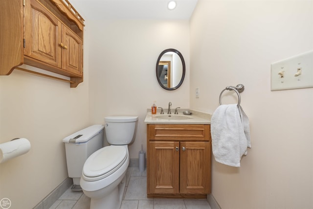 half bathroom featuring baseboards, vanity, toilet, and tile patterned floors