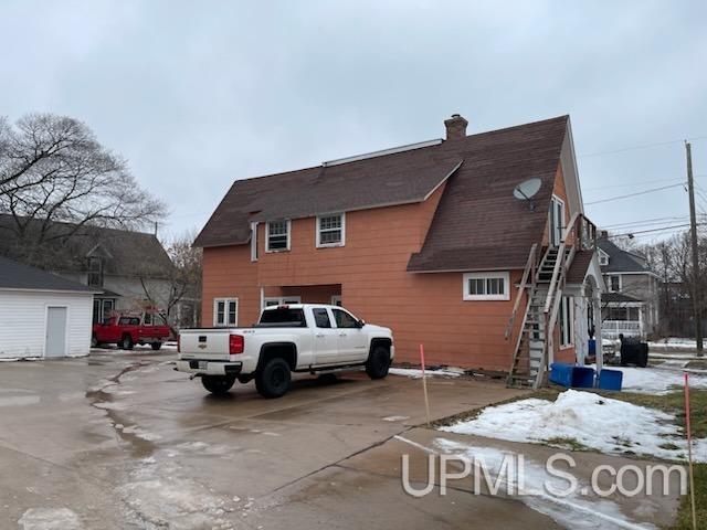 view of property exterior featuring a chimney and stairway