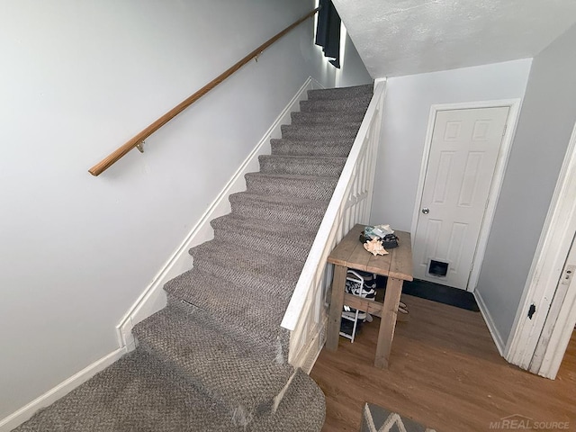 stairs with baseboards and wood finished floors