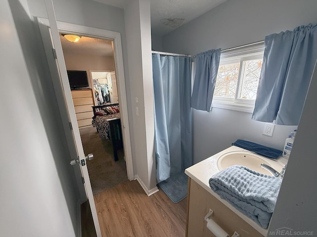 bathroom with curtained shower, wood finished floors, and vanity