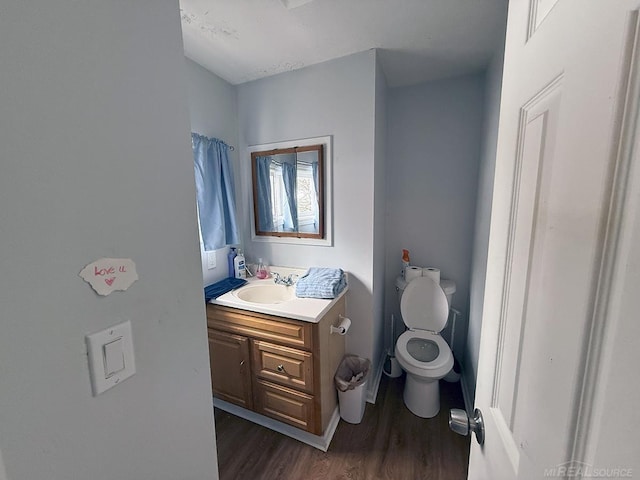 bathroom with toilet, wood finished floors, and vanity