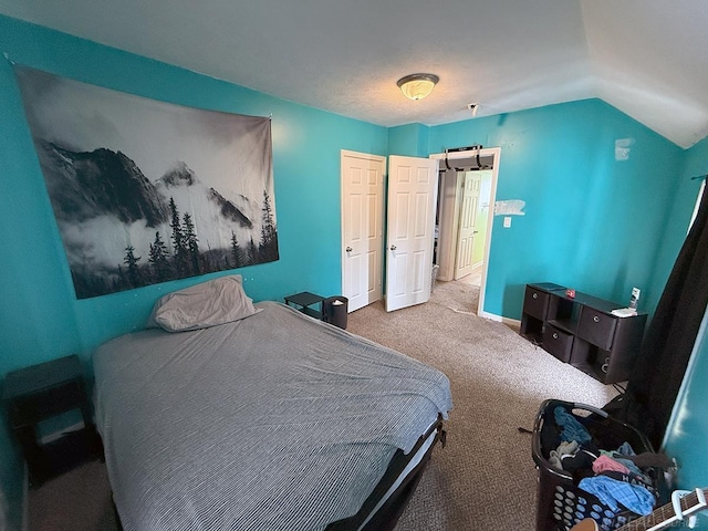 bedroom with lofted ceiling, carpet, and baseboards