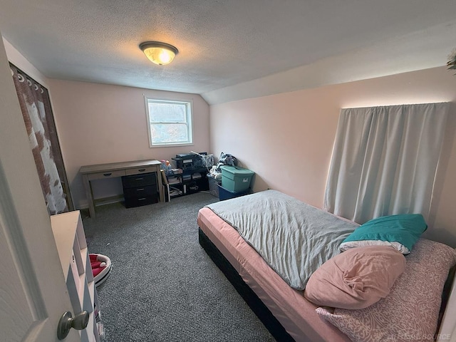 bedroom featuring lofted ceiling, dark carpet, and a textured ceiling