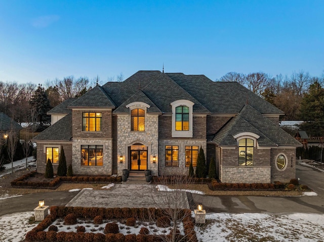 french country home featuring roof with shingles