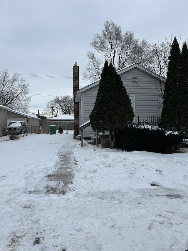 snow covered property with a chimney