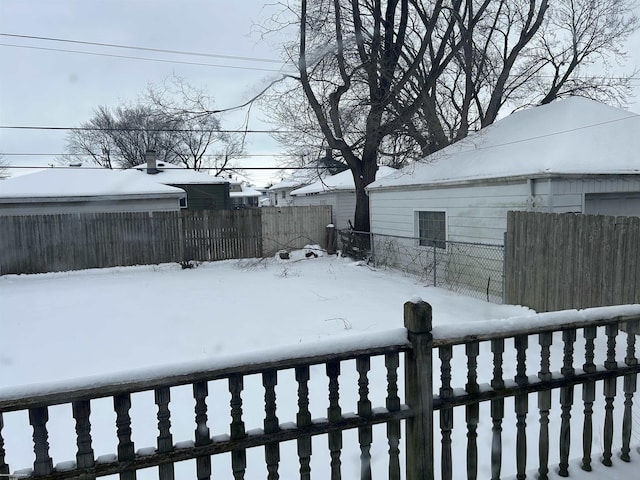 yard covered in snow with fence