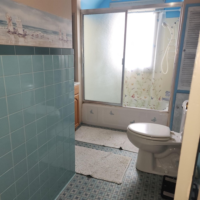 full bathroom with tile patterned flooring, toilet, shower / bath combination with glass door, tile walls, and wallpapered walls