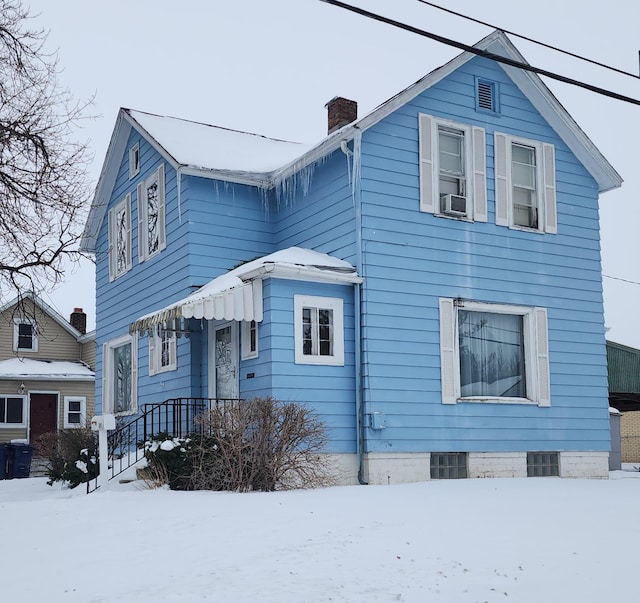 traditional-style house featuring cooling unit and a chimney