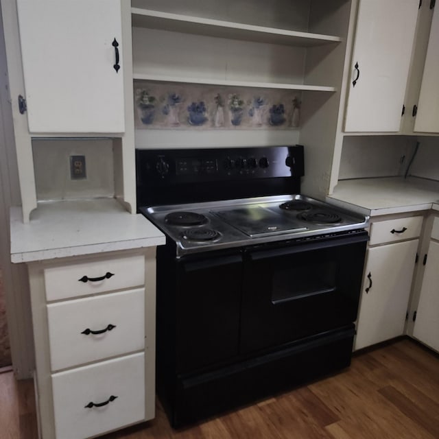 kitchen with white cabinets, wood finished floors, black range with electric stovetop, light countertops, and open shelves