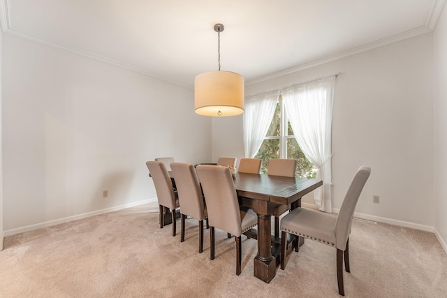 dining room featuring ornamental molding, light colored carpet, and baseboards