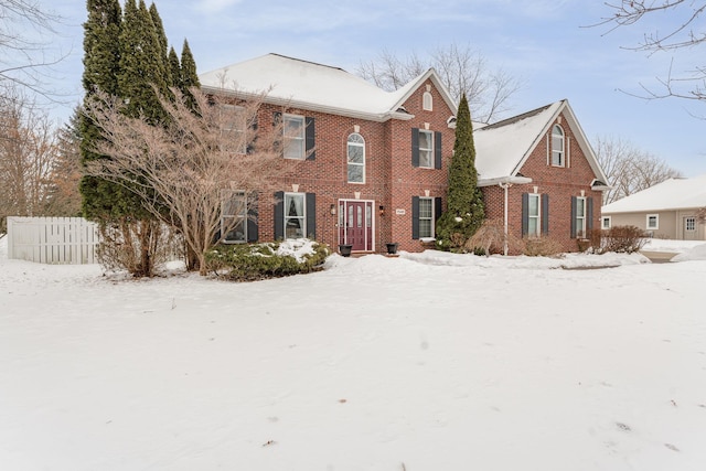 view of front facade featuring fence and brick siding