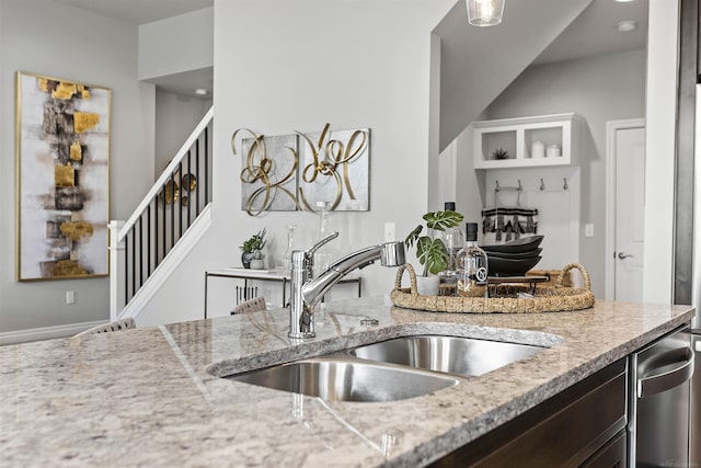 kitchen featuring a sink and light stone countertops