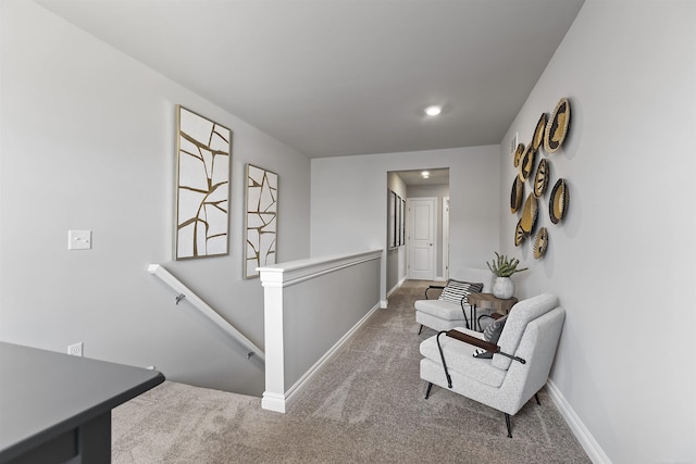 corridor featuring carpet, an upstairs landing, and baseboards